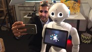 Selfie von Reporter Michel Abdollahi mit Robotor Pepper  
