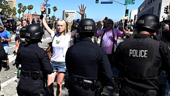 Frau hebt Hände hinter Polizeikette © Keith Birmingham/The Orange County Foto: Keith Birmingham