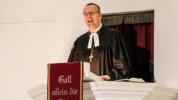 Ein Bischof im Talar predigt auf einer Kanzel. © epd-bild Foto: Jens Schulze
