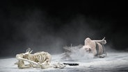 Eine Frau liegt auf einer Bühne neben einem Skelett. © Thomas Aurin 