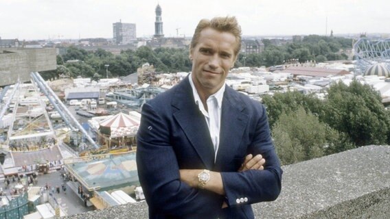 Arnold Schwarzenegger im August 1986 über dem Hamburger Dom bei einem Pressetermin zum Kinostart von "Der City Hai". © IMAGO / teutopress 