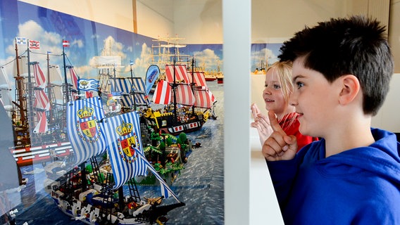 Kinder bestaunen Koggen und Schiffe aus Lego-Steinen in der Ballinstadt in einer Ausstellung © Stein Hanse 