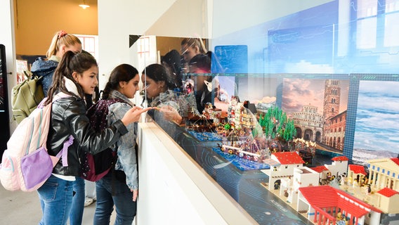 Jugendliche bestaunen Koggen und Schiffe aus Lego-Steinen in der Ballinstadt in einer Ausstellung © Stein Hanse 