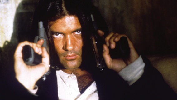 Filmstill "Desperado" (1995): Schauspieler Antonio Banderas hält zwei Pistolen an seine Schläfen © Filmfest München 