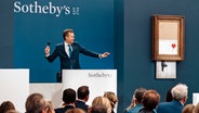 Im Auktionshaus Sotheby's wird das Banksy-Werk "Love is the Bin" versteigert. © dap bildfunk/Sotheby's Auction House/AP Foto: Haydon Perrior