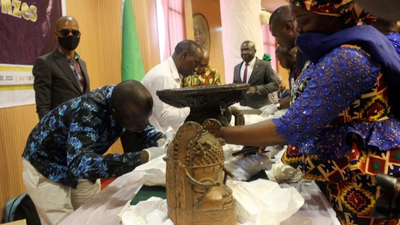 Benin-Bronzen, die in der Vergangenheit geraubt und an Nigeria zurückgegeben wurden, werden während einer Übergabezeremonie ausgestellt. © picture alliance/dpa/AP | Olamikan Gbemiga 