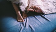 Nahaufnahme der Füße des Paares im Bett © imago/Photocase Foto: -