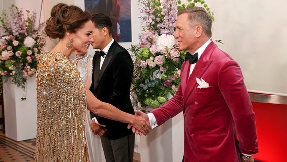 Herzogin Kate schüttelt Daniel Craig die Hand. © picture alliance / ASSOCIATED PRESS / Chris Jackson 
