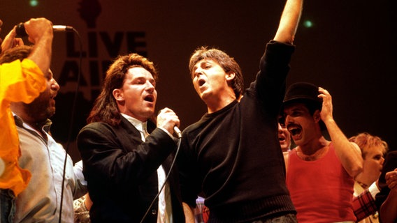 U2-Sänger Bono singt beim Live Aid mit Paul McCartney. U2-Sänger Bono singt beim Live Aid mit Paul McCartney. © picture alliance / Pa/PA Wire/dpa | Pa