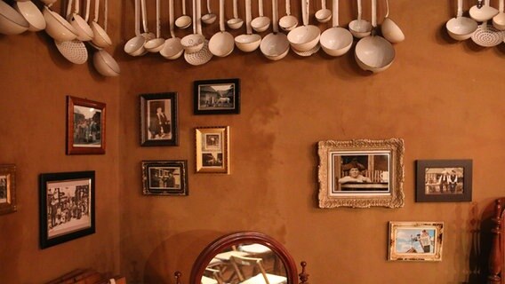 Suppenkellen hängen an den Wänden eines Raumes. © NDR Foto: Claudio Campagna