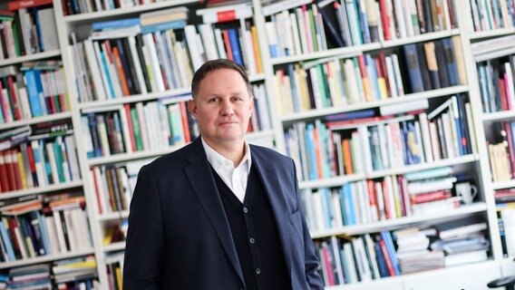 Hamburgs Kultursenator Carsten Brosda vor einer Bücherwand. © picture alliance / dpa Foto: Christian Charisius