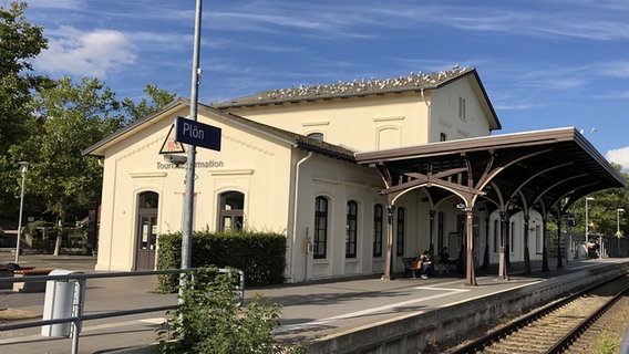 Das Bahnhofsgebäude in Plön mit Gleis und Stationsschild  Foto: Anina Pommerenke