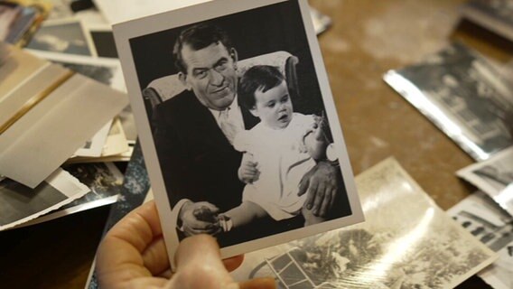 Eine Hand hält ein Foto von Curt Bloch und einem kleinen Kind © Screenshot NDR 