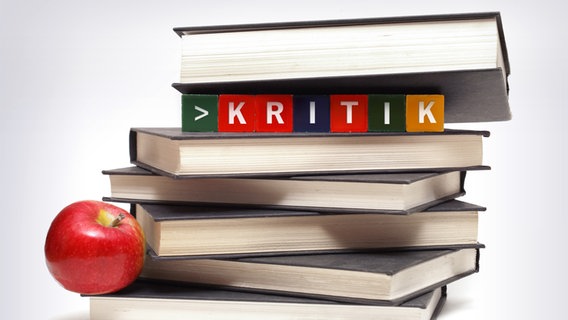 Ein Buchstapel mit Würfel die das Wort "Kritik" ergeben. © fotolia.com Foto: Matthew Benoit