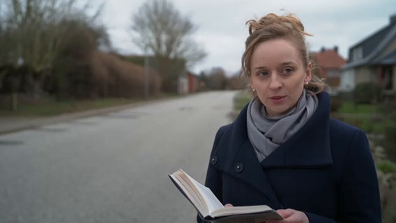 Autorin Alina Herbing hält ein Buch in der Hand © NDR Screenshot 