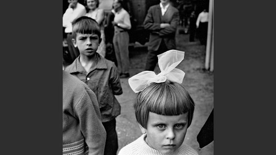 Schwarz-weiß Foto: Mädchen mit großer Haarschleife. © Steidl Verlag Foto: Antanas Sutkus