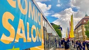 Eine Menschenschlange vor einem Messegebäude. © NDR Foto: Mathias Heller