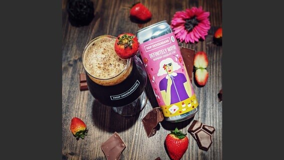 Eine rosa Bierdose der Marke Hop Hooligans neben einem Glas mit dunklem Bier, dekoriert mit Erdbeeren und Schokoladenstückchen © Design Diana Barbu, Photo Courtesy of Hop Hooligans, Craft Beer Design, gestalten 2022 