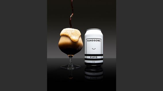 Eine schwarz-weiße Bierdose mit der Aufschrift ""Handsome. Elvis", daneben ein rundes, überschaumendes Glas, in das dunkles Bier eingegossen wird. Dunkelgrauer Hintergrund © Design Balter & Lachie Goldsworthy, Photo Ben Trueman, Craft Beer Design, gestalten 2022 