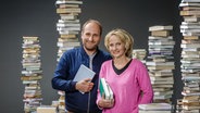 Daniel Kaiser und Katharina Mahrenholtz stehen vor Bücherstapeln. © NDR/ Claudius Hinzmann Foto: Claudius Hinzmann
