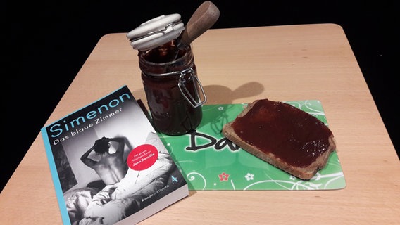 Ein Buch von George Simenon auf einem Tisch mit dem Essen von Folge 17 des Literaturpodcasts "eat.READ.sleep" © NDR Foto: Jan Ehlert