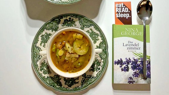 Suppe Pistou eingefüllt in eine Tasse neben einem Buch von Nina George - Eat Read Sleep Folge 21 © NDR 