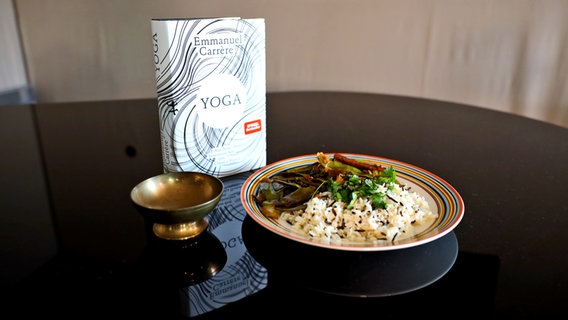 Ein Buch neben einem Teller mit Gemüse-Reis - Folge 60 von eat.READ.sleep © NDR Foto: Lisa Nietiedt