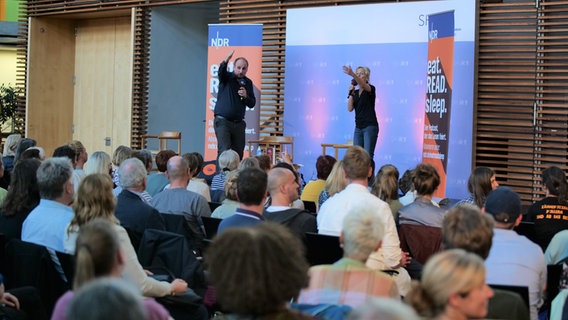 Zwei Personen auf einer Bühne gestikulieren vor Publikum © NDR Foto: Torsten Heitmann