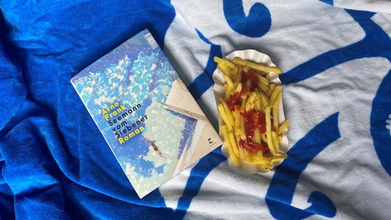 Der Roman "Seemann vom Siebener" von Arno Frank liegt neben eine Schale mit Pommes. © NDR 