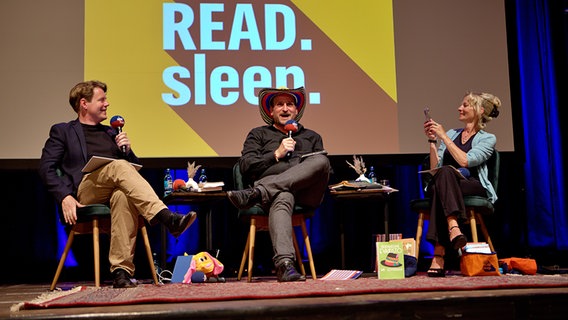 Die drei Hosts des Podcasts eat.READ.sleep. zu Gast in Schwerte auf der Bühne - inklusive Cowboyhut © NDR / c_ruhrpottfoto.de Foto: c_ruhrpottfoto.de