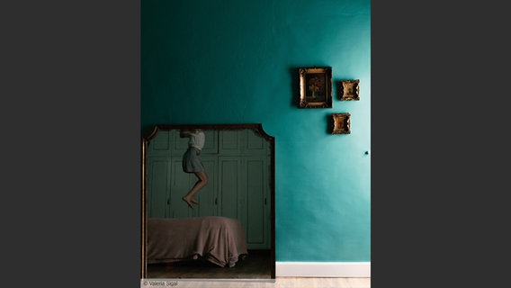 Eine Frau springt auf einem Bett; Bild von Valeria Sigal aus: "Eye Mama", teNeues Verlag © Valeria Sigal 