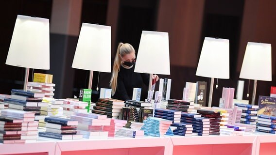 Eine Mitarbeiterin der Frankfurter Buchmesse an einem Buchstand in der Festhalle © dpa Bildfunk Foto: Arne Dedert