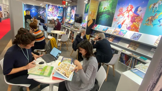 Händlerinnen sichten Comics auf der Frankfurter Buchmesse 2023 © NDR.de / Christina Grob Foto: Christina Grob