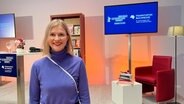 Eine Frau mit kinnlangen Haaren und blauen Pulli steht lächelnd vor einer Bühne der Berlinale (Autorin Claudia Scharf bei "Books at Berlinale") © NDR Foto: Patricia Batlle