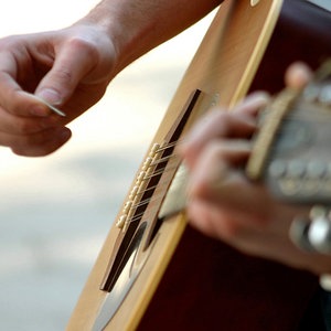 Zwei Hände spielen auf einer Gitarre. © Fotolia.com Foto: Georg Tschannett