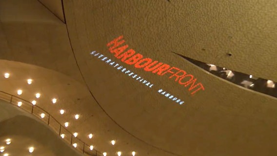 Die Aufschrift Harbour Front Literaturfestival projiziert auf die Wand im Großen Saal der Elbphilharmonie Hamburg © NDR Screenshot 