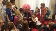 Olivia Jones liest einer Gruppe von Kindern vor © picture alliance/dpa/www.olivia-jones.de | -- 