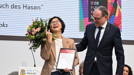 Martin Buhl-Wagner remet le prix de la Foire du livre de Leipzig dans la catégorie traduction à Ki-Hyang Lee.  © photo alliance/dpa |  Hendrik Schmidt 