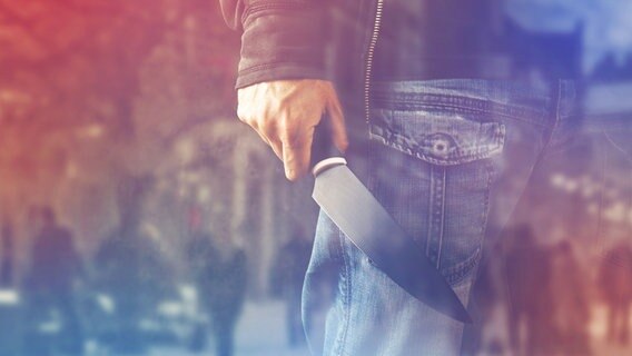 Ein Mann in Jeans hält ein Messer in der Hand. © fotolia Foto: Bits and Splits
