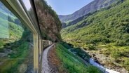 Zug fährt durch eine Berglandschaft © picture alliance / blickwinkel Foto: H. Blossey