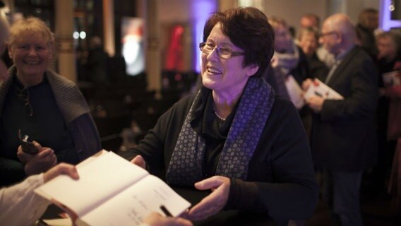 Eine Dame lässt sich ein Buch signieren  Foto: Stefan Albrecht