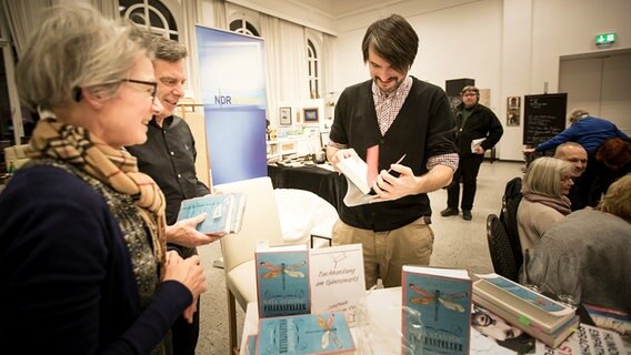 Saša Stanišić mit Menschen an einem Bücherstand © NDR Foto: Stefan Albrecht