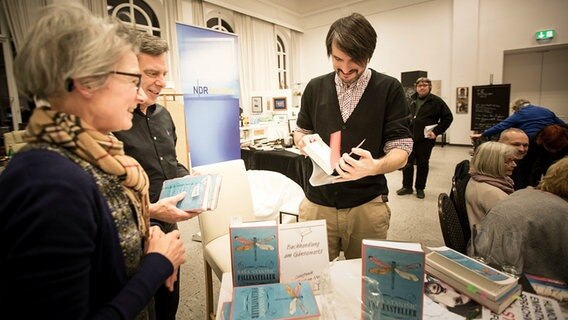 Saša Stanišić mit Menschen an einem Bücherstand  Foto: Stefan Albrecht