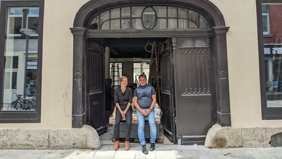 Eine Frau und ein Mann sitzen in einem Torbogen, oben drüber steht Literaturhaus Göttingen. © Frederik Schulz-Greve / NDR Foto: Frederik Schulz-Greve