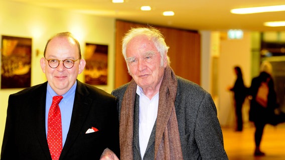 Denis Scheck und Martin Walser stehen Arm in Arm nebeneinander. © IMAGO / Horst Galuschka 