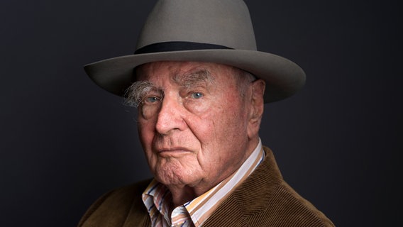 Ein Mann hat einen Hut auf und guckt in die Kamera. © picture alliance/KEYSTONE | GAETAN BALLY 