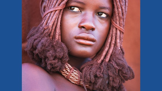 Die große Bedeutung des Viehs spiegelt sich in der Kleidung, Frisur und dem ästhetischen Empfinden der Himba wider. Der rötliche Glanz von Haut und Haaren stammt von einer Paste, die die Mädchen und Frauen auftragen, damit ihre Köpfe und Körper wie das Fell eines jungen Kalbes schimmern. © Michael Poliza / teNeues 