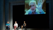 Beim Internationalen Literaturfestival Berlin stellt Schriftsteller Salman Rushdie, live aus New York zugeschaltet, sein Buch "Victory City" vor, während ihn Schriftsteller Daniel Kehlmann (2.v.l.) und Bernhard Robben (l), Übersetzer des Buches von der Bühne aus begrüßen. Schauspielerin Cynthia Micas (r) las darin. © dpa Foto: Annette Riedl