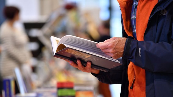 Ein Mann liest in einem Buch. © picture alliance / Martin Schutt/dpa-Zentralbild/dpa | Foto: Martin Schutt