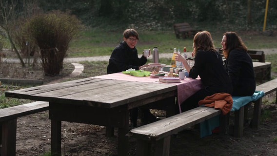 Drei Frauen sitzen an einem Picknicktisch © NDR Screenshot 